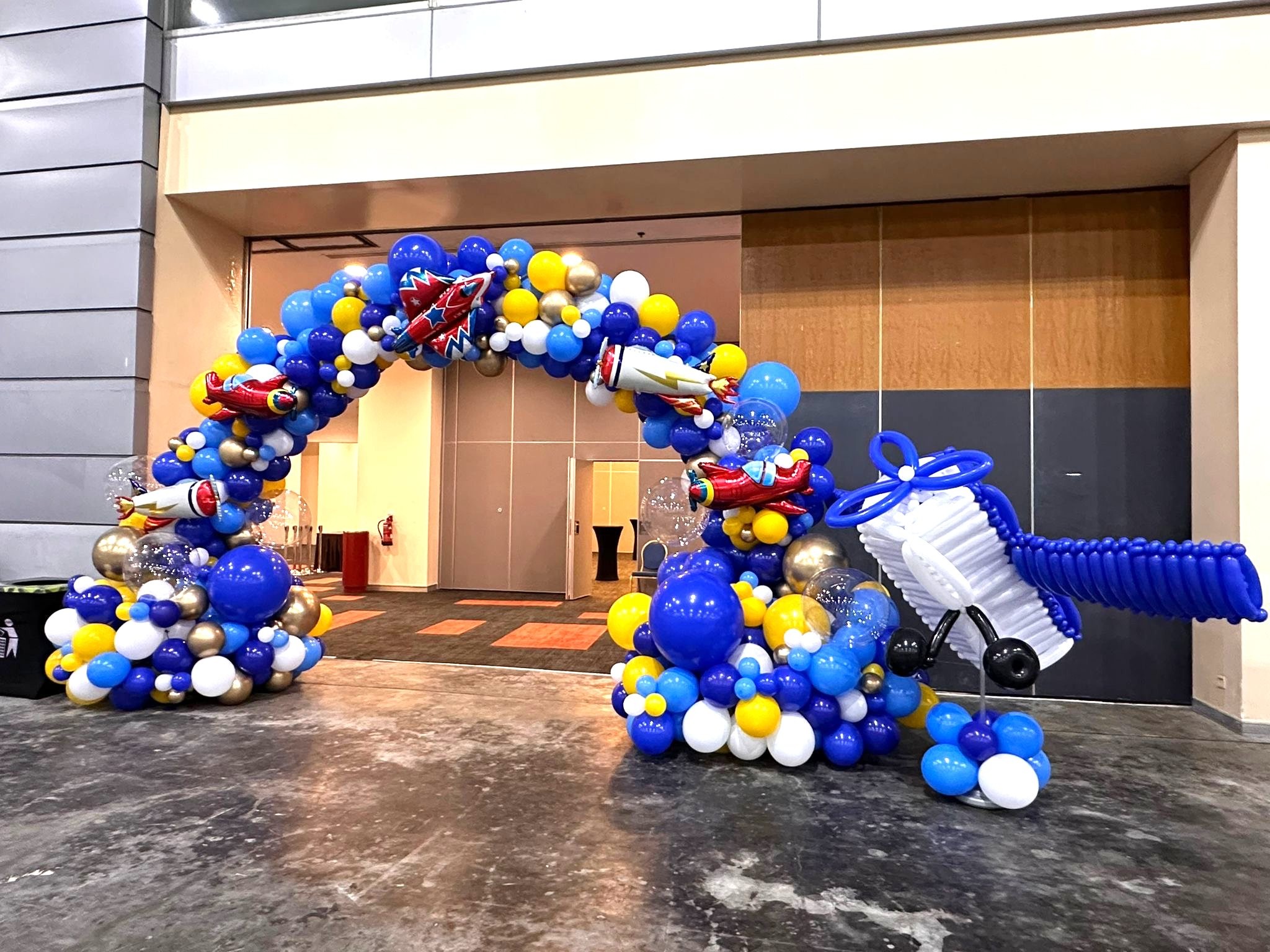 Aviation themed organic balloon arch with airplane sculpture corporate balloon decorations Singapore