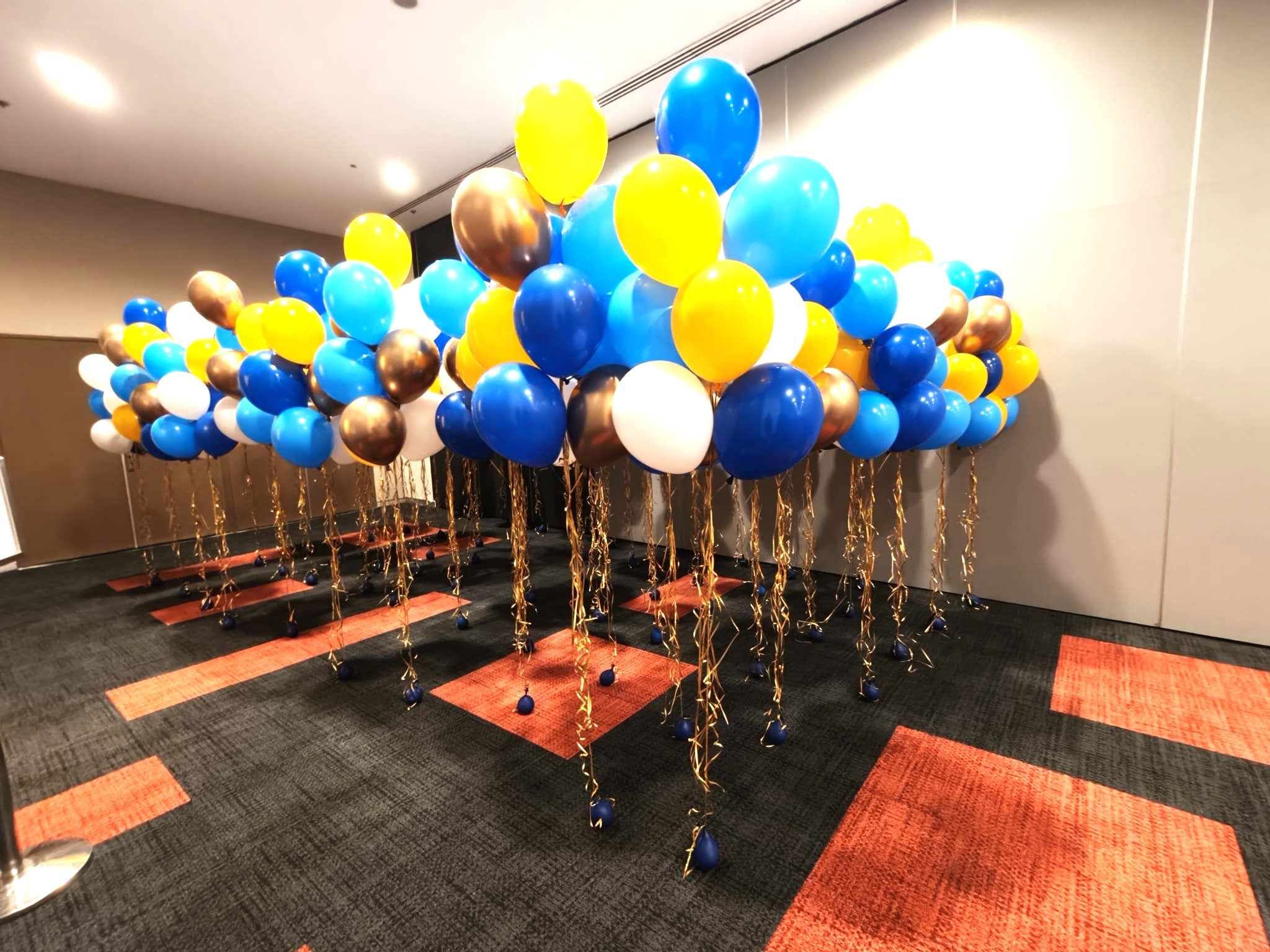 Helium balloon clusters in gold blue and yellow at corporate event Singapore