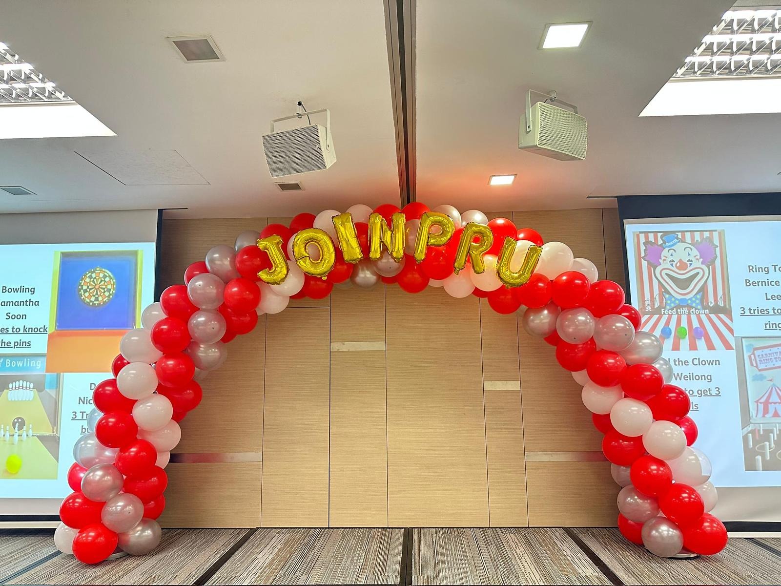 Red and white balloon arch with gold lettering
