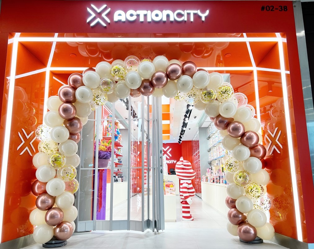 White and rose gold balloon arch around a retail entrance