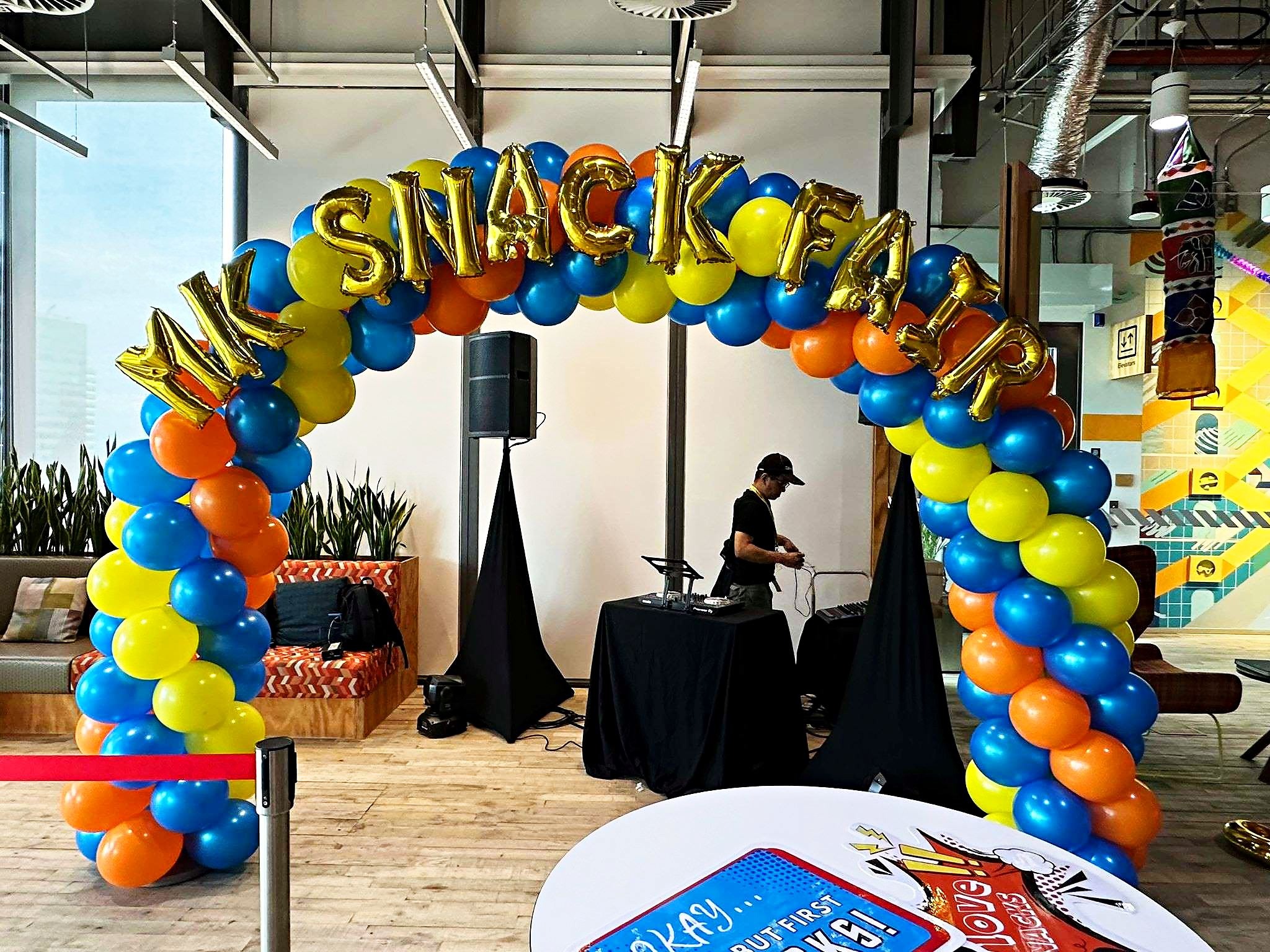 Blue yellow and orange balloon arch at a snack fair