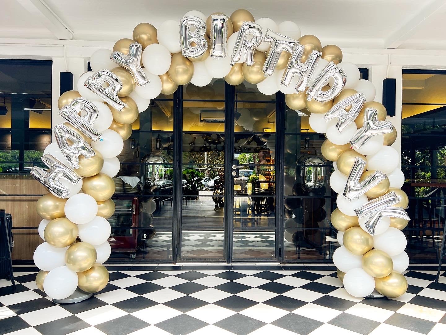 White and gold birthday balloon arch