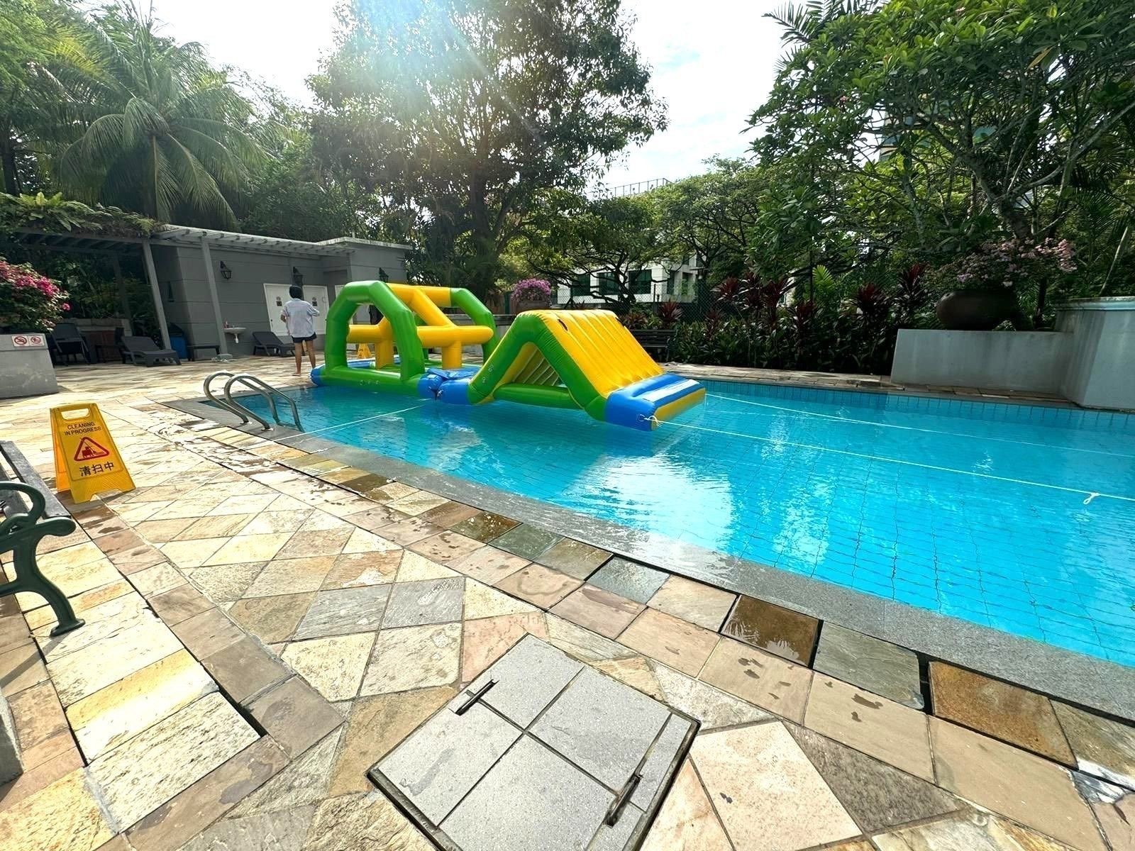 Compact inflatable water slide and arch obstacle at an outdoor condominium pool Singapore
