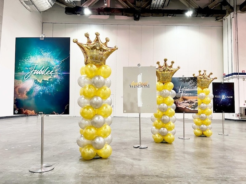 Yellow white and silver balloon pillars topped with gold crowns