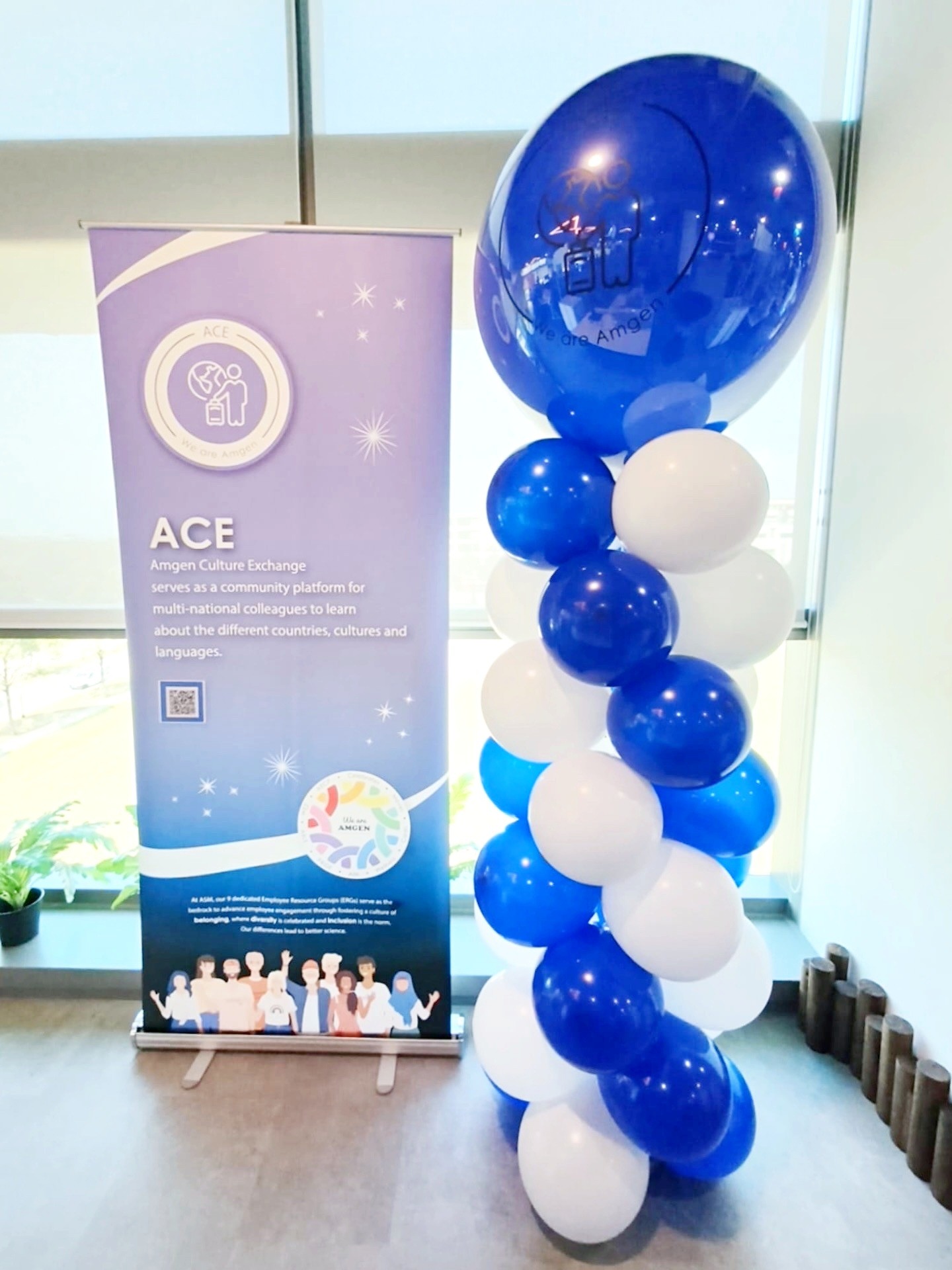 Blue and white spiral balloon column beside a corporate sign