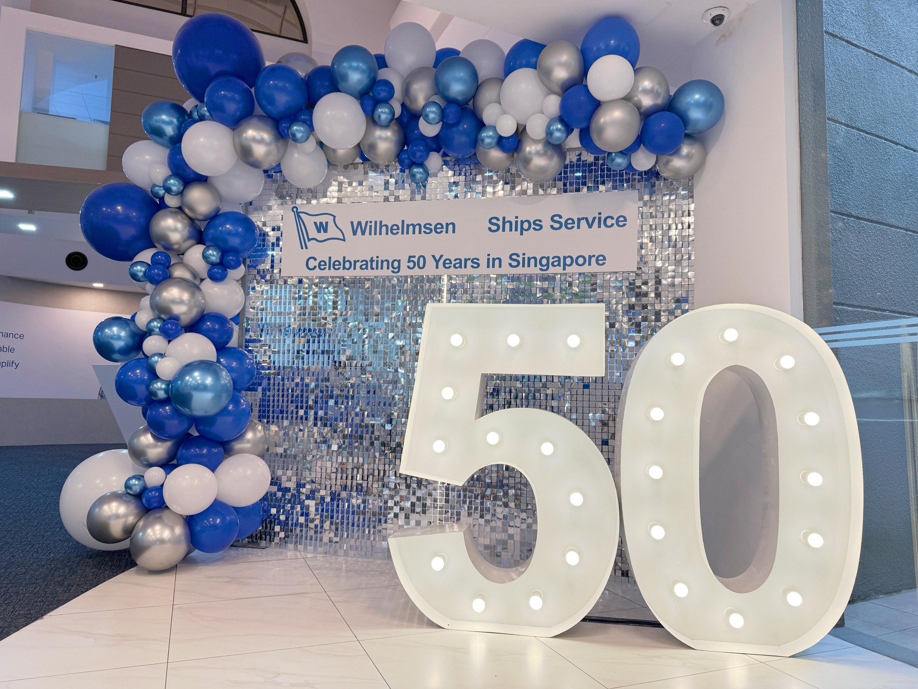 Blue white and silver balloon backdrop with illuminated anniversary numbers