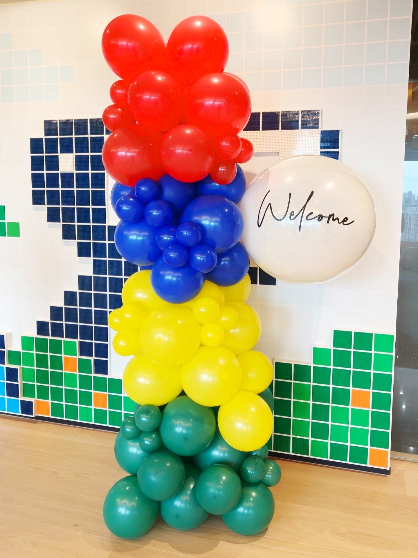 Red blue yellow and green balloons framing a welcome sign