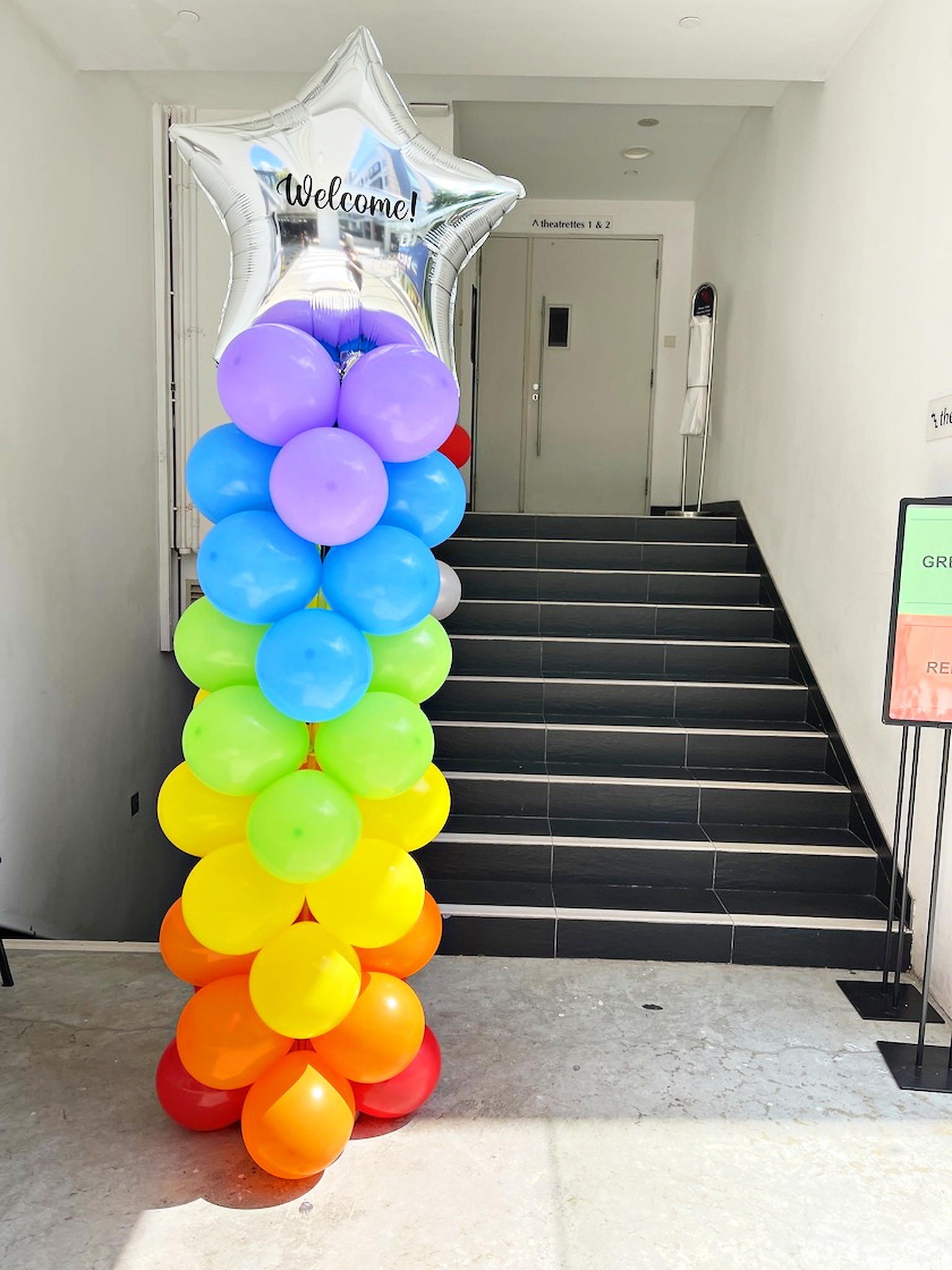 Rainbow balloon column with a silver star topper