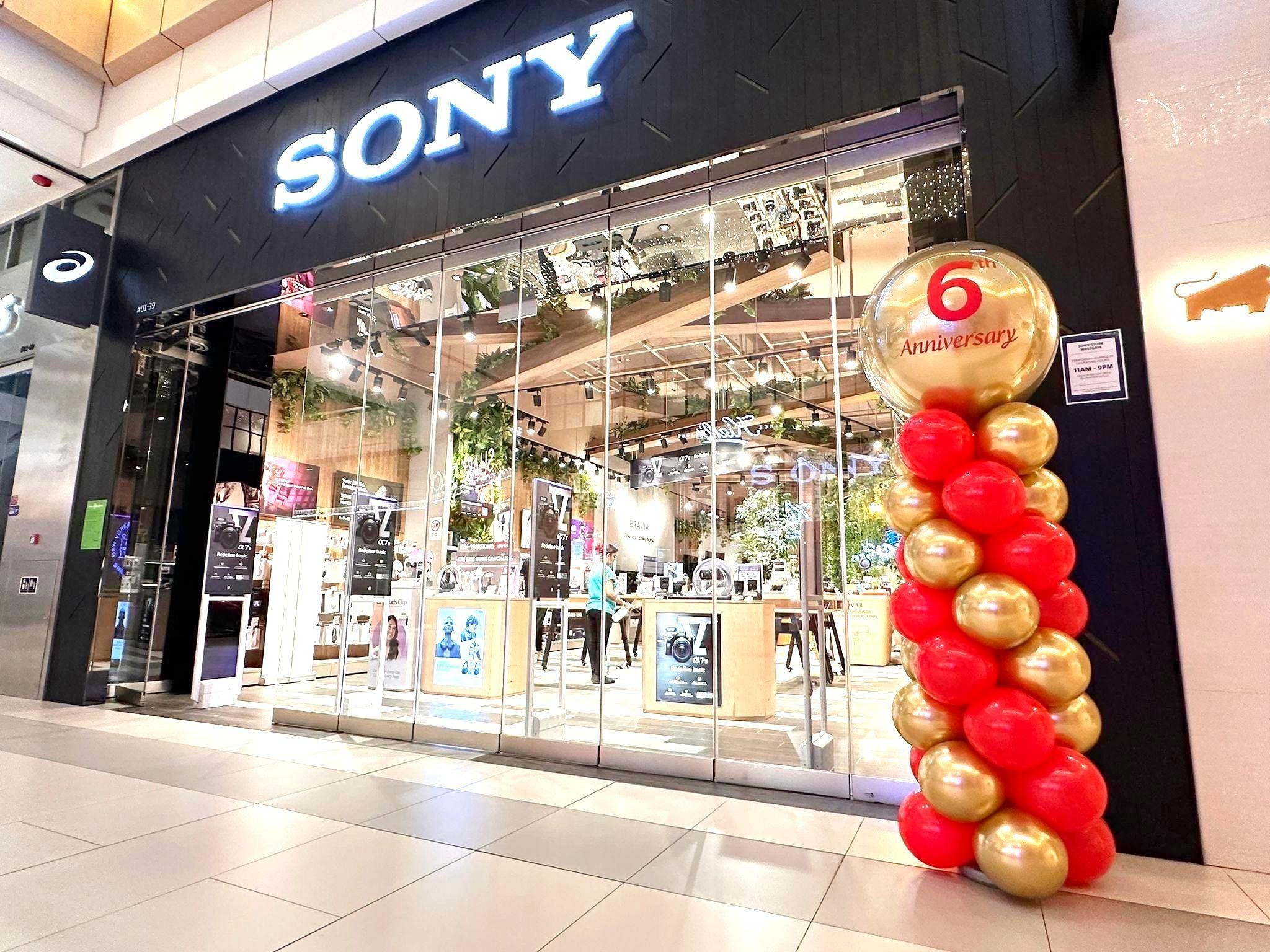 Red and gold balloon column outside a store anniversary display