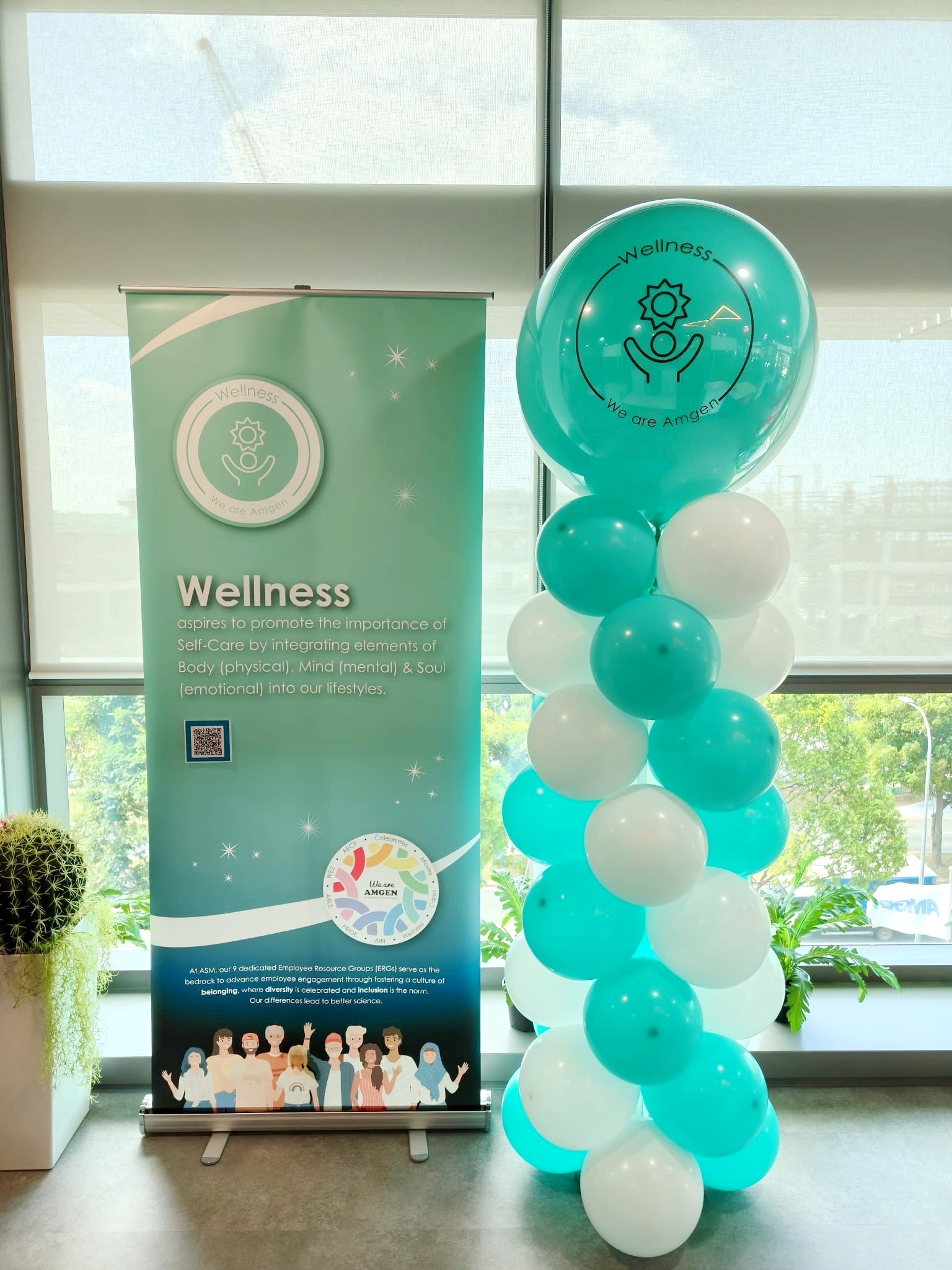 Teal and white balloon column coordinated with a wellness banner